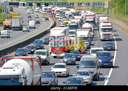 Stau Autobahnraststätte & Feuerwehrfahrzeuge auf Rettungsdiensten rufen an, um Unfallort zu erreichen, während Autos & Lieferwagen versuchen, sich auf der m25 UK zu entfernen Siehe Hinweis Stockfoto