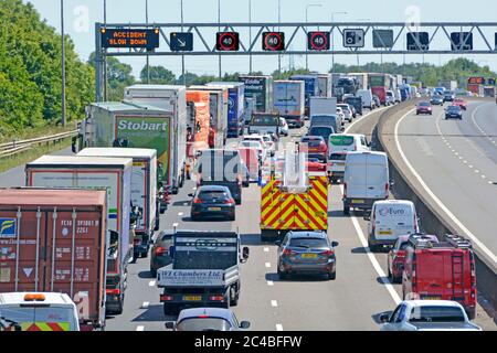 Autobahnraststätte Stau & Feuerwehrmotor auf Rettungsdienst rufen Unfallort in der Nähe von Brentwood zu erreichen, wie auf m25 Gantry Road Sign UK gezeigt Stockfoto