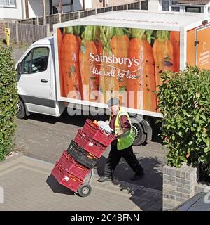 Sainsburys Supermarkt Lebensmittelgeschäft Lieferung van geparkten Luftbild Fahrer Wheeling Lebensmittel in Kisten aus Online-Internet-Shopping-Auftrag zu Haus Essex UK Stockfoto