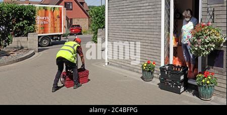 Coronavirus covid 19 Maske auf Senior Rentner Hausfrau sozial distanzieren Sainsburys Supermarkt Lebensmittel einkaufen Lieferung van & Fahrer Essex UK Stockfoto