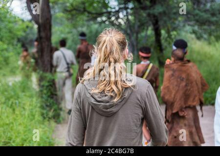 Touristen auf einem Wanderweg mit Mitgliedern der San People, Buschmänner in Botswana Stockfoto