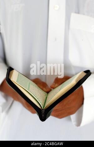 Muslimischer Mann beim Lesen eines arabischen heiligen koran (koran) Stockfoto