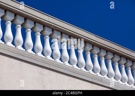 Weiße Steinbalustraden über der Wandarchitektur des Barock gegen den blauen Himmel an einem sonnigen Tag. Stockfoto