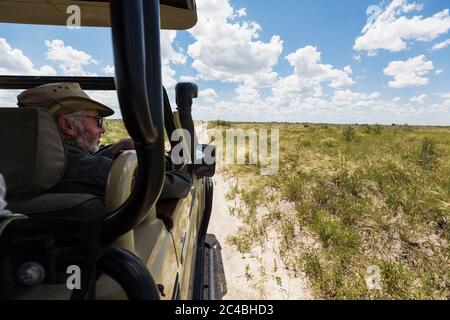 safari-Führer und Fahrzeug auf unbefestigten Straße Stockfoto