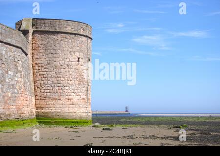 Mittelalterlicher Coxon's Tower, der über die Mündung des Flusses Tweed in Richtung Nordsee blickt, mit Berwick Lighthouse in der Ferne. Stockfoto