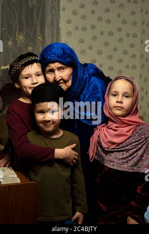 Alte muslimische Großmutter in Hijab und muslimische Enkelkinder Stockfoto