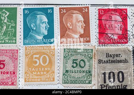 Deutsche Briefmarken im Briefmarkenalbum - Hitler-Portraitkopf und Großmarken-Hyperinflationsmarken und Bayerische Staatsbahn-Briefmarke Stockfoto