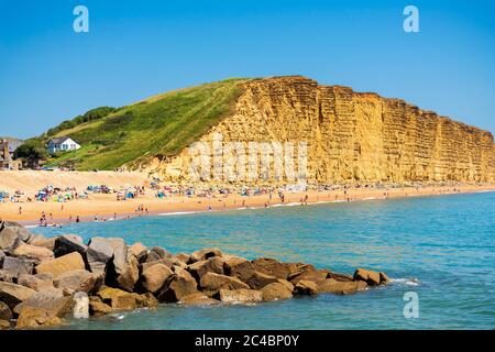 West Bay Dorset am Meer mit Menschen genießen das Sommerwetter am Strand, Großbritannien. Stockfoto