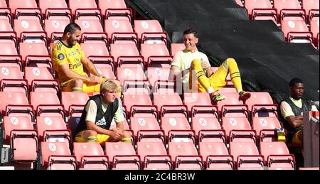 Mesut Ozil (rechts) von Arsenal sitzt in der Tribüne, die sich während des Premier League-Spiels in St. Mary's, Southampton, von seinen Teamkollegen entfernt. Stockfoto