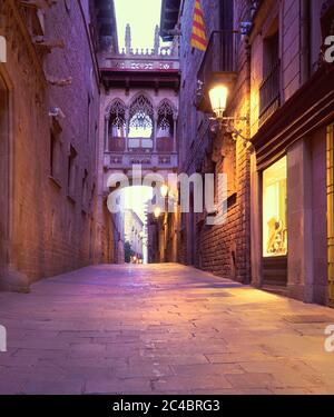 Beleuchtete mittelalterliche Straße Carrer del Bisbe mit Seufzerbrücke im Barri Gothic Quarter, Barcelona, Katalonien, Spanien Stockfoto