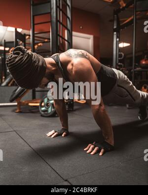 Ein sportlicher Mann im Fitnessstudio macht Yoga-Übungen, übt im Stehen in der Plank-Pose, macht Push-up oder Push-up-Übungen, Training, für die abgedeckt Stockfoto