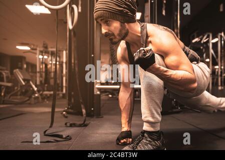 Ein sportlicher Mann im Fitnessstudio macht Yoga-Übungen. Virabhadrasana: Die Position des Kriegers. Geistige Vorteile des Yoga. Stockfoto