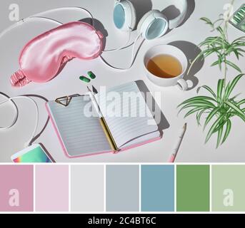 Farblich passende Palette von gesunden Schlaf Stillleben in rosa und grün. Schlafmaske, Kopfhörer, Tee, Schlaftabletten, Tagebuch-Notizbuch. Silbergrau Stockfoto