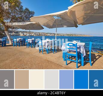 Farblich passende Palette aus dem Bild des leeren kretischen Restaurants mit blauen Stühlen und Tischen unter Sonnenschutz am Meer von Rethymno Stockfoto