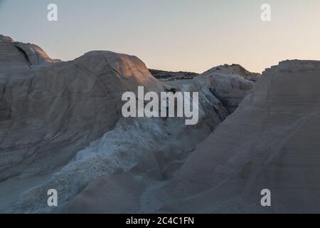 Ein Mann, der bei Sonnenuntergang durch den Sarakiniko Strand in Milos, Griechenland, wandert Stockfoto