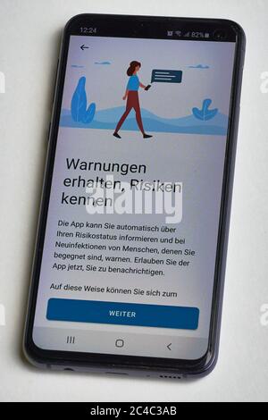 Warnung mit der Corona Warn App. Smartphone-App zur Bekämpfung der Corona-Pandemie in Deutschland. Stockfoto