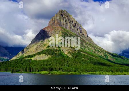 5044 Grinnell Point steht vor einer Wolkenkulisse am Swiftcurrent Lake des Glacier National Park Stockfoto