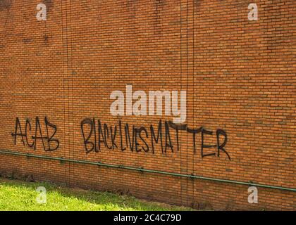 Black Lives Matter ACAB auf der Seite eines Backsteingebäudes gemalt Stockfoto