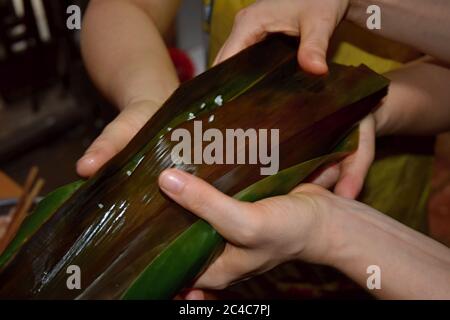 Zongzi, ein traditionelles chinesisches Reisgericht, das aus klejeweidem Reis besteht, der mit verschiedenen Füllungen gefüllt und in Bambusblätter eingewickelt ist. Stockfoto