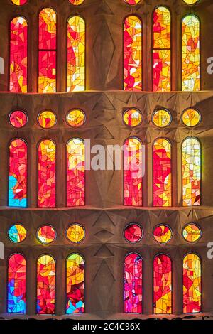 Auf der einen Seite spiegeln die Buntglasfenster der Sagrada Familia die untergehende Sonne wider, mit warmen Rot-, Orangen- und Gelbtönen; auf der anderen Seite kühlen Morgenfarben Stockfoto