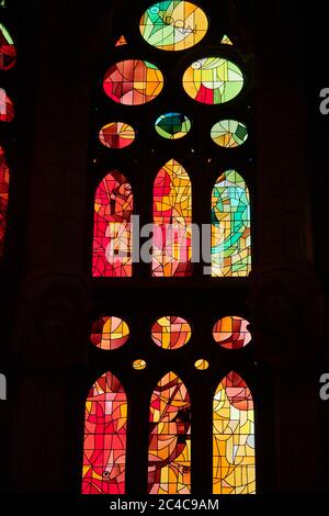 Auf der einen Seite spiegeln die Buntglasfenster der Sagrada Familia die untergehende Sonne wider, mit warmen Rot-, Orangen- und Gelbtönen; auf der anderen Seite kühlen Morgenfarben Stockfoto