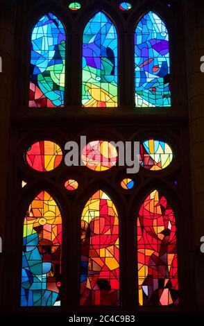 Auf der einen Seite spiegeln die Buntglasfenster der Sagrada Familia die untergehende Sonne wider, mit warmen Rot-, Orangen- und Gelbtönen; auf der anderen Seite kühlen Morgenfarben Stockfoto