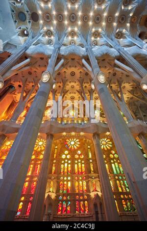 Auf der einen Seite der Sagrada Familia nutzen die Buntglasfenster die untergehende Sonne, mit warmen Rot-, Orangen- und Gelbtönen. Stockfoto