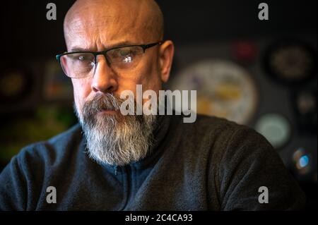 Älterer Mann mit grauem Bart sieht ernst Stockfoto