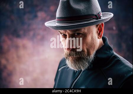 Älterer Mann mit grauem Bart, der eine Fedora trägt Stockfoto