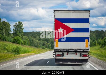 Ein LKW mit der Nationalflagge Kubas auf der Hintertür trägt Waren in ein anderes Land entlang der Autobahn. Konzept Export-Import,transpo Stockfoto