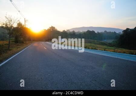 Eine lange kurvige Straße im Berg bei Sonnenaufgang Stockfoto