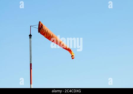 Eine Orange Windsack oder Windfahne gegen den blauen Himmel Stockfoto