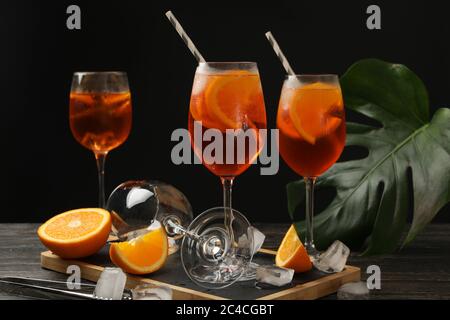 Komposition mit aperol Spritz Cocktail vor schwarzem Hintergrund. Sommergetränk Stockfoto