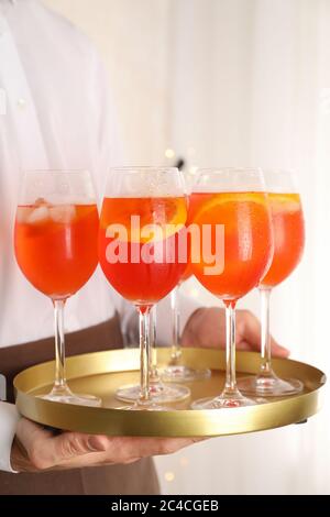 Kellner hält Tablett mit aperol Spritz Cocktail. Sommergetränk Stockfoto