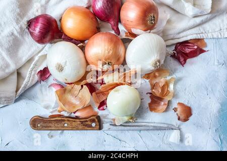 Reinigung frischer Zwiebeln in der Küche. Draufsicht Stockfoto