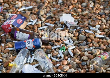 Brighton UK 26. Juni 2020 - Nitroxid-Gasbehälter zwischen Müllhaufen am Brighton Strand und am Meer heute Morgen, die von den Massen von Besuchern gestern zurückgelassen wurden, der bisher heißeste Tag des Jahres war : Credit Simon Dack / Alamy Live News Stockfoto