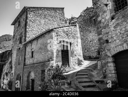 Ein Blick auf das kleine Dorf Stifone, an der Nera. Eine gepflasterte Gasse zwischen den Steinhäusern. Eine Treppe. Die Wände aus Steinen und Ziegel Stockfoto