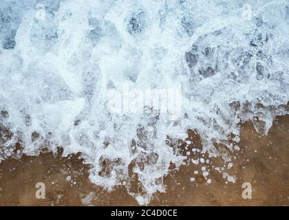 Makroaufnahme des Meeres, das auf den Strandsand spritzt Stockfoto