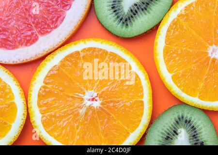 Zitrusfrüchte, tropischer Hintergrund. Grapefruitscheiben, Kiwi, Orange. Sommer bunte Tapete Stockfoto
