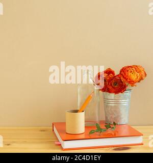 Innenausstattung. Arbeits- und Studienplatz. Notizbuch, Bleistift mit Blumendekor auf Holzschreibtisch mit beigem Hintergrund. Kopierraum Stockfoto