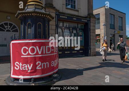 Großes rotes Warnschild Covid-19, 2 m auseinander bleiben, mit geschlossenem Geschäft hinter dem Hotel. Stourbridge. West Midlands. GROSSBRITANNIEN Stockfoto