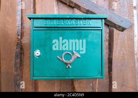 KRAUSNICK, DEUTSCHLAND - 01. Jan 2020: Krausnick, Brandenburg/Deutschland - 11.01.2020: Ein grüner Briefkasten mit einem Posthorn auf der Vorderseite, der an einem befestigt ist Stockfoto