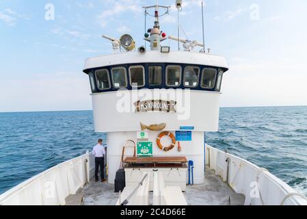 FEHMARN, DEUTSCHLAND - 03. Sep 2019: Ein altes weißes Stahlboot für Ausflüge und Angelausflüge auf der Ostsee mit technischer Ausrüstung und der Brücke Stockfoto