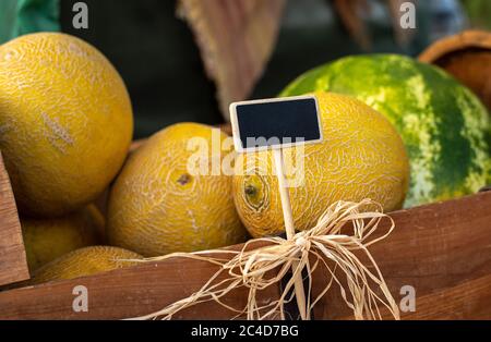 Ausstellung von lokal angebauten Melonen zum Verkauf auf lokalen Bauernmarkt mit handgeschriebenem Kreidetafel Schild Stockfoto