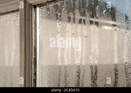 Das Innere eines alten Häuschen, das während eines Winters morgens starke Kondensation auf den Innenfenstern zeigt. Die Holzrahmen sind sichtbar. Stockfoto