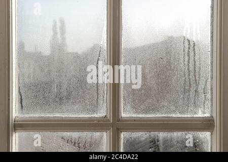 Das Innere eines alten Häuschen, das während eines Winters morgens starke Kondensation auf den Innenfenstern zeigt. Die Holzrahmen sind sichtbar. Stockfoto