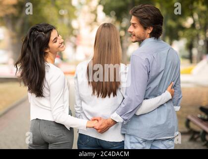 Betrügen Ehemann Hände mit Frau Freund zu Fuß in Park halten Stockfoto