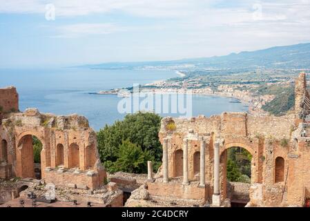 Das antike römisch-griechische Amphitheater mit der Giardini Naxos Bucht im Hintergrund in Taormina, Sizilien, Italien Stockfoto