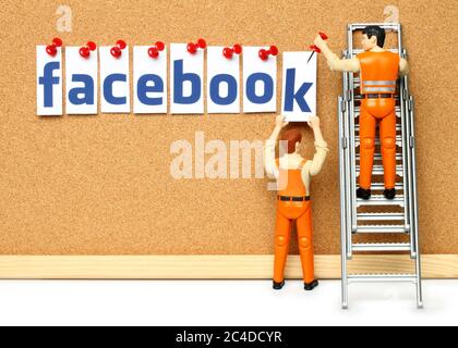 Kiew, Ukraine - 27. November 2019: Zwei Spielzeugmänner Pin Buchstaben von Facebook Wort auf Korkbrett. Facebook ist ein bekannter Dienst für soziale Netzwerke Stockfoto
