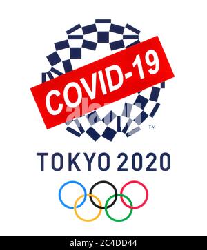 Kiew, Ukraine - März 20,2020: Logo der Olympischen Sommerspiele 2020 Tokio, Japan, auf Papier gedruckt, durchgestrichen mit Papierschild COVID-19. Die Olympischen Spiele waren postpo Stockfoto